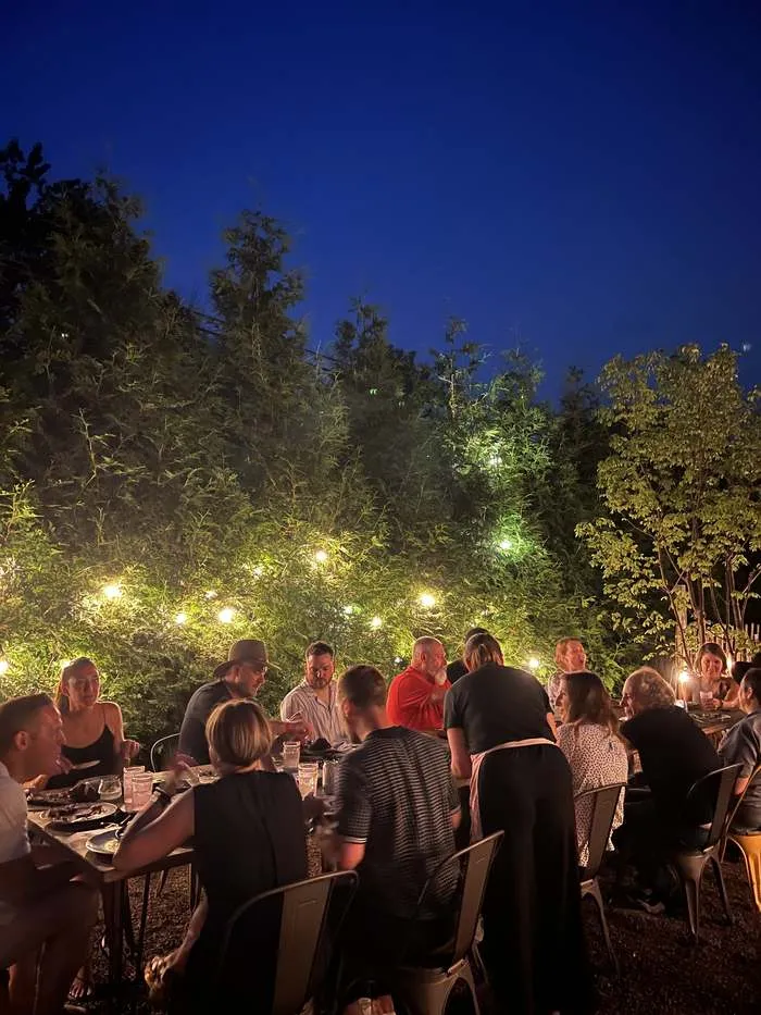 Guests gathered at the table under string lights at night
