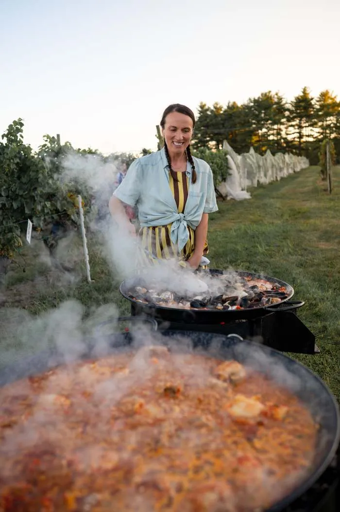 Chef VJ cooking paella over open fire in a Bucks County vineyard
